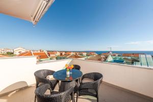 a balcony with a table and chairs and the ocean at Enna house with private jacuzzi in Novalja