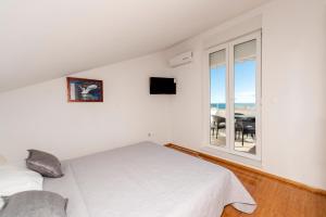 a bedroom with a bed and a window with a table at Enna house with private jacuzzi in Novalja
