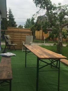 una mesa de madera y 2 sillas en el césped en Blue house, en Suchedniów