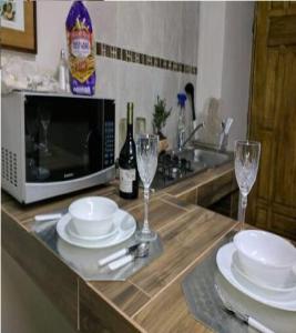 a kitchen counter with plates and glasses and a microwave at Tec, Brisas y Sur de Mty 54633 in Monterrey +6 photos