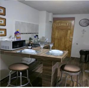 a kitchen with two bar stools and a microwave at Tec, Brisas y Sur de Mty 54633 in Monterrey