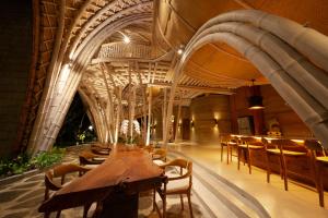Ulaman Eco Luxury Resort في تابانان: غرفة طعام مع طاولة وكراسي