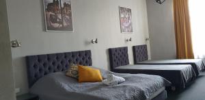 a bedroom with two beds and a tufted headboard at Résidence Tournet in Krakow
