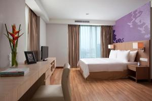 
a bedroom with a large bed and a large window at Citadines Rasuna Jakarta in Jakarta
