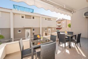 a patio with chairs and a table on a balcony at Enna house with private jacuzzi in Novalja
