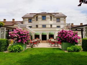 a large house with pink flowers in the yard at Hotel Sonnenhof in Suceava