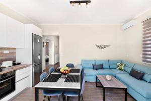 a living room with a blue couch and a table at Endless sea view house in Nea Iraklia