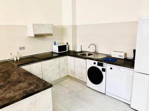 a kitchen with a sink and a washing machine at lolf with jacuzzi in malaga in Málaga