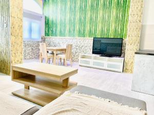 ein Wohnzimmer mit einem Tisch und einem TV in der Unterkunft lolf with jacuzzi in malaga in Málaga