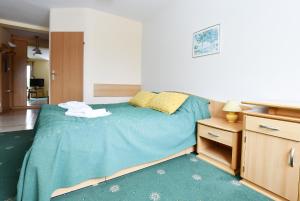 Schlafzimmer mit einem Bett mit blauer Decke in der Unterkunft Apartament 14A in Kołobrzeg