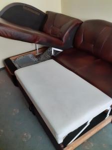 a leather couch with a foot rest in a room at Kołobrzeg-hotel Polonia apartament 207 in Kołobrzeg