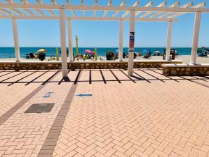 a pavilion at the beach with the ocean in the background at Fuengirola, Playa Carvajal in Fuengirola