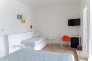 a bedroom with a bed and a desk with a television at AllYouCanTrip - Porto in Naples