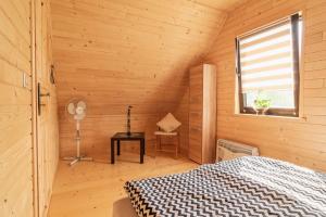 1 dormitorio con 1 cama en una habitación de madera en Domki na Jurze, en Kroczyce