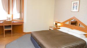 a hotel room with a bed and a desk and a window at Hotel Clio Court Hakata in Fukuoka