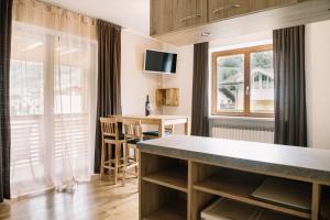 a kitchen and living room with a table and a desk at Apartments Gletscherblick in Kaprun