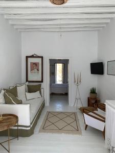 a white living room with a couch and a table at Serifos Olive in Serifos Chora