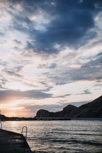 una vista de un cuerpo de agua con un cielo nublado en 5 Hermoupolis Concept Sites, en Ermoupoli