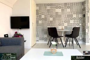 a living room with a couch and a table and chairs at Wellness Bungalow Bolder 5p Amsterdam and the beach in Opmeer