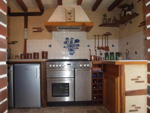 a kitchen with a stainless steel stove and refrigerator at Gîtes les Terriers in Saint-Jean-Froidmentel