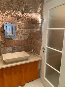 a bathroom with a sink and a brick wall at Apartments Aurora Delle Rose in Assisi