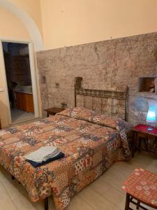 um quarto com uma cama e uma parede de tijolos em Apartments Aurora Delle Rose em Assis