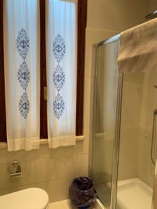 a bathroom with a shower curtain and a toilet at Apartments Aurora Delle Rose in Assisi