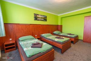 two beds in a room with green walls at Hotel Hvězda in Kroměříž