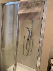 um chuveiro com uma porta de vidro na casa de banho em Apartments Aurora Delle Rose em Assis