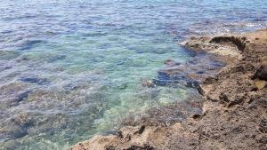a body of water next to a rocky shore at Piccolo Hotel in Rosignano Solvay