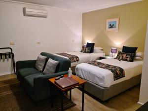 a hotel room with two beds and a couch at Oyster Cove Chalet in Kettering