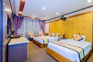 a hotel room with two beds and a table at Hoa Dao Hotel in Hòa Bình