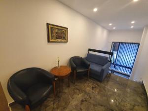 uma sala de estar com duas cadeiras e uma mesa em Premium Crown Suites em Belgrado