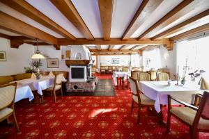 a dining room with tables and chairs and a fireplace at Hotel Zur Post in Balve