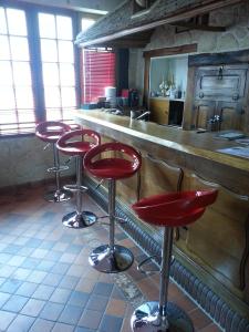 a bar with four red stools in front of a counter at Le Pingouin in Bennecourt