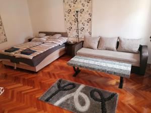 a living room with a bed and a couch at Kriston Apartman in Miskolc