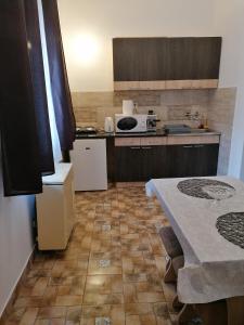 a small kitchen with a table and a microwave at Kriston Apartman in Miskolc