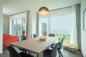 a dining room with a table and chairs and a large window at Ferienwohnung Arguna in Langenargen