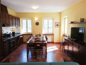 una cucina con tavolo, sedie e televisore di Case Vacanze Borgo Faraldi a Villa Faraldi