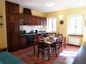 uma cozinha com uma mesa e algumas cadeiras e uma cozinha com em Case Vacanze Borgo Faraldi em Villa Faraldi