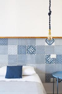 um quarto com uma cama com uma parede azul e branca em Canceddi Rooms em Palermo