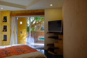 a bedroom with a tv and a bed and a balcony at The Weenee Boutique in Hat Yai