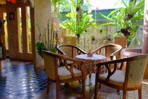 a table and chairs in a room with plants at The Weenee Boutique in Hat Yai