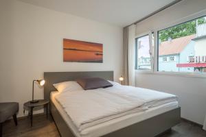 a bedroom with a large bed with a window at Ferienwohnung Montfort in Langenargen