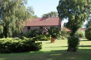 a house with a red roof and a green yard at Ivy House Country Hotel in Lowestoft