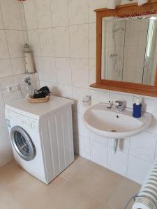 a bathroom with a washing machine and a sink at Haus Marianne in Weilheim