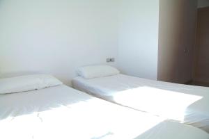 dos camas sentadas una al lado de la otra en un dormitorio en Sotell Apartment Gran Via Europa BCN, en Las Corts