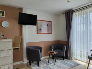 a living room with two chairs and a window at Haus Marianne in Weilheim