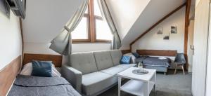 a living room with a couch and a bed at Pod Sową in Sokolec