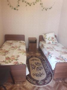 アドレルにあるГостевой домのベッド2台とラグが備わる客室です。